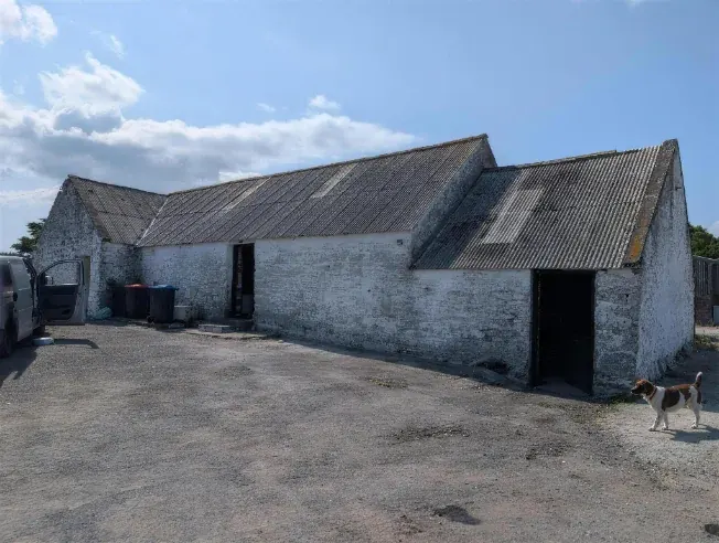 Stone farm steading with a corrugated asbestos cement roof awaiting removal